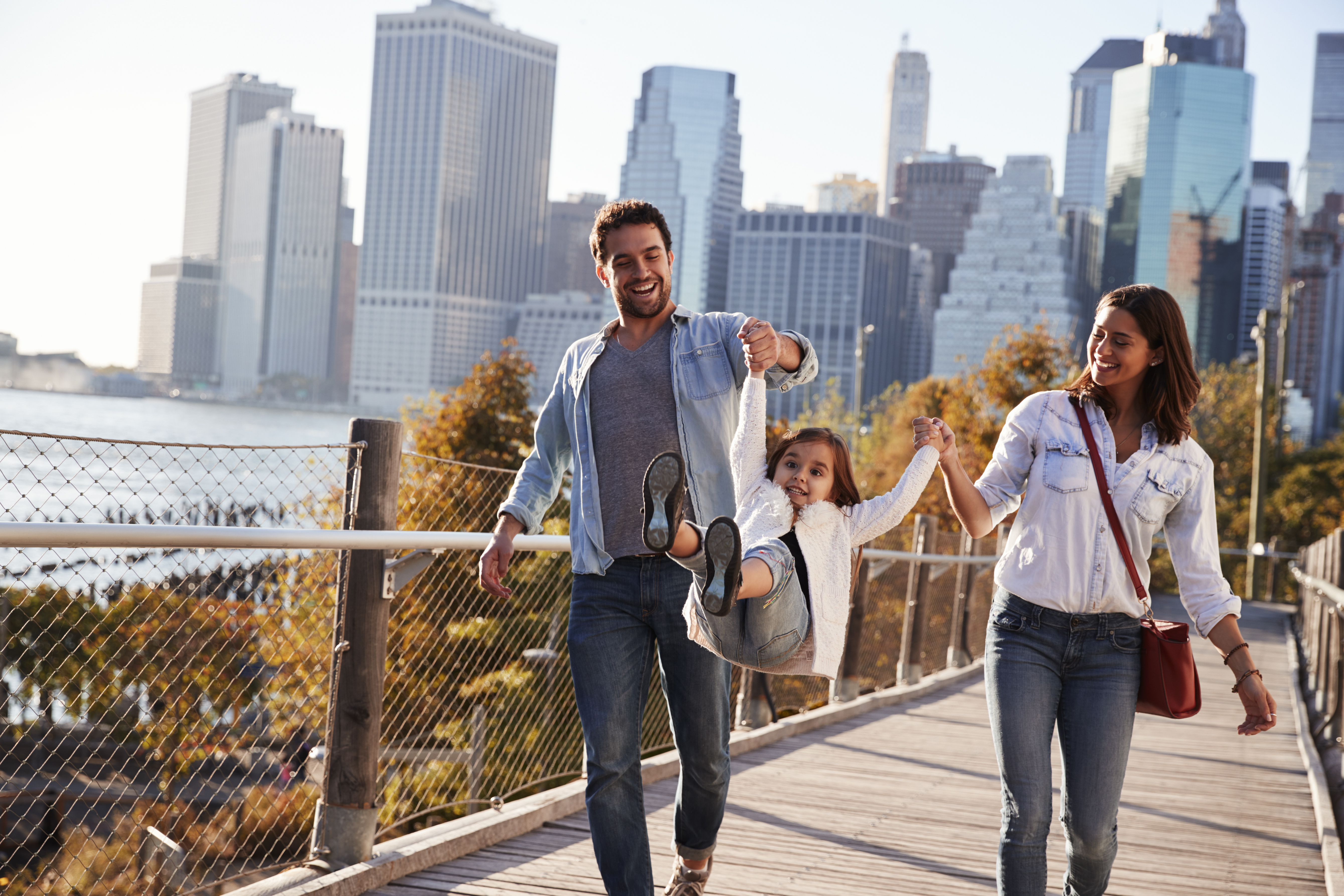 Young family with daughter taking a walk on footbridge
